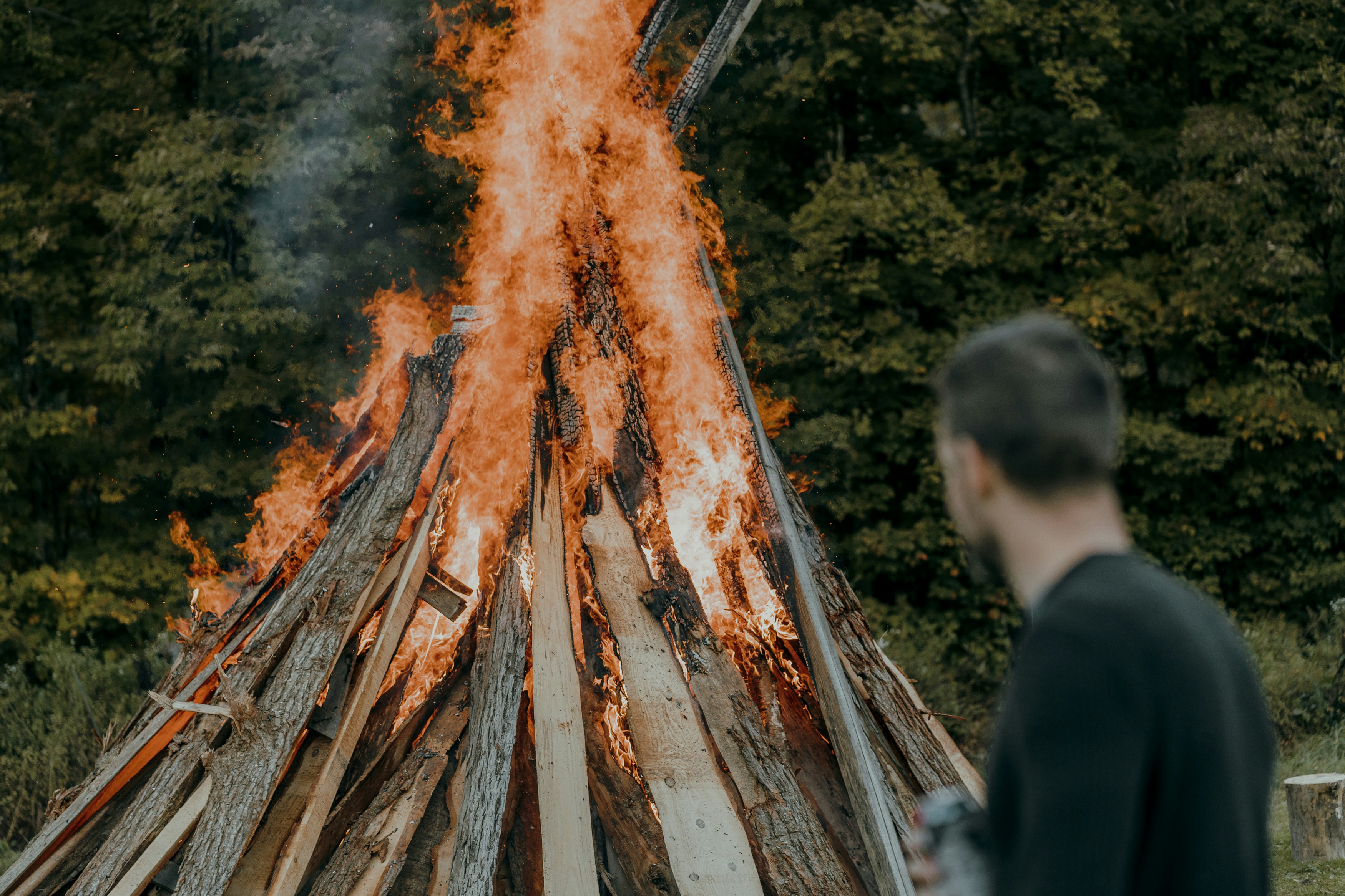 Justin Cronk, founder of The Heroes' Journey, watching a fire